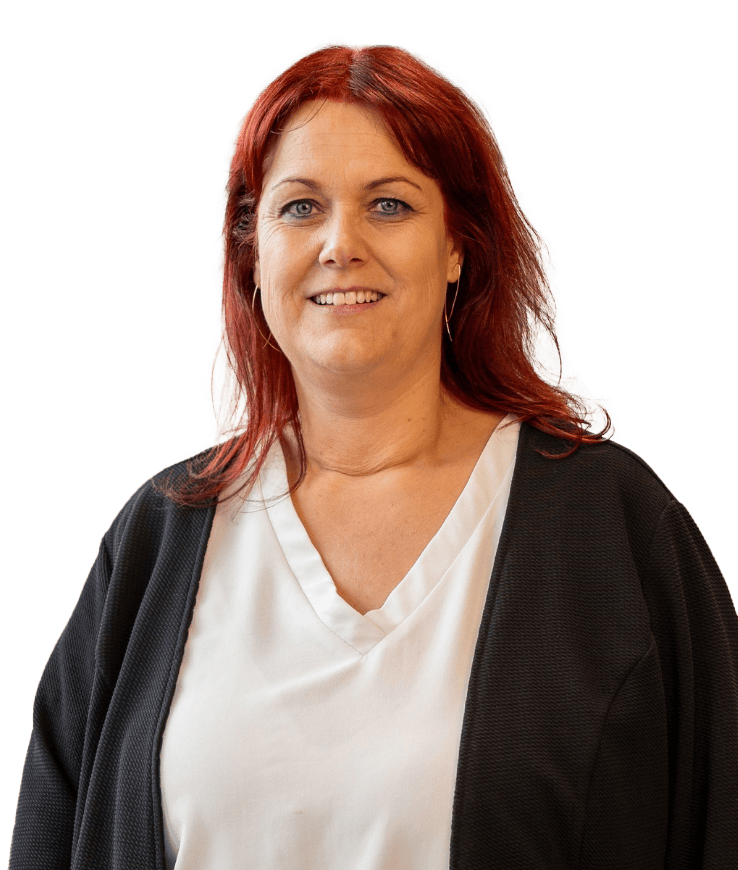 Frau mit schulterlangem roten Haar trägt weiße Bluse und schwarzen Cardigan