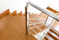 Treppe aus Holz mit stabilen Metallhandläufen.